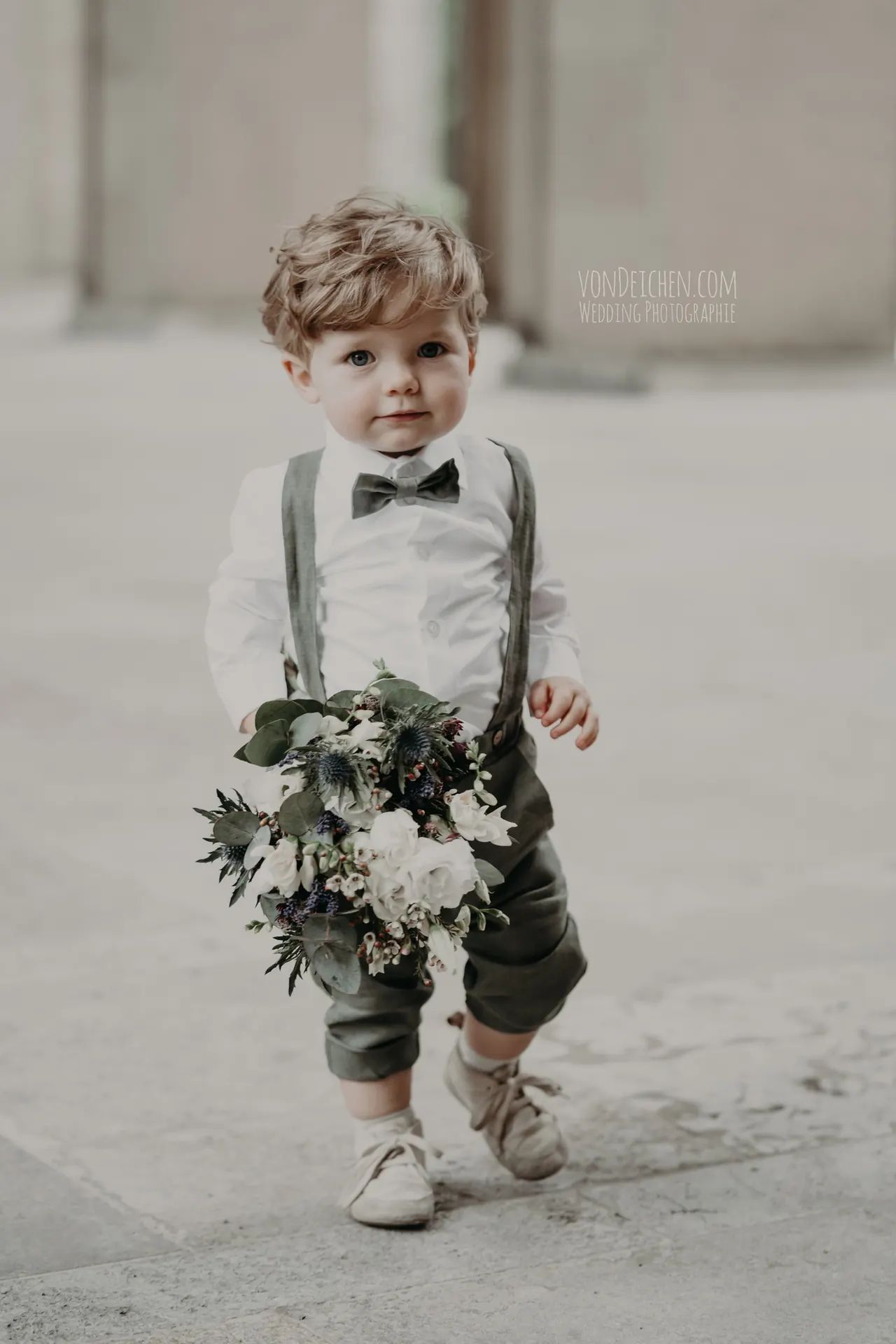 Kleiner Junge mit Hosenträgern und Blumenstrauß